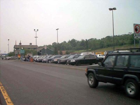 2000 Ford Crown Victoria - A black SUV is in the foreground with a row of parked cars behind it.