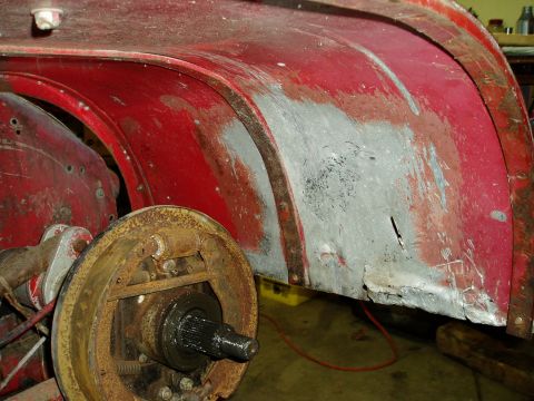 2000 Ford E350 - Close-up view of the rear wheel well and brake drum, showing signs of rust and repair.