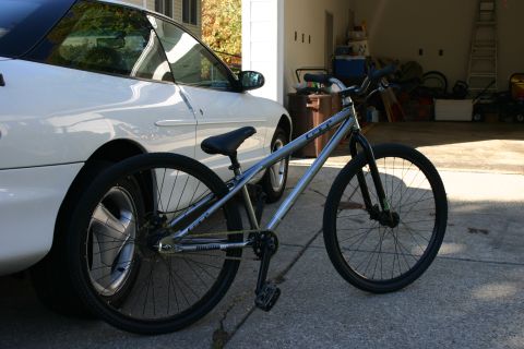 1997 Ford Probe - A white 1997 Ford Probe is parked next to a bicycle in a driveway.