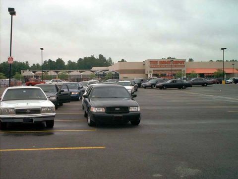 2000 Ford Crown Victoria - A black 2000 Ford Crown Victoria is seen in a parking lot with other vehicles.