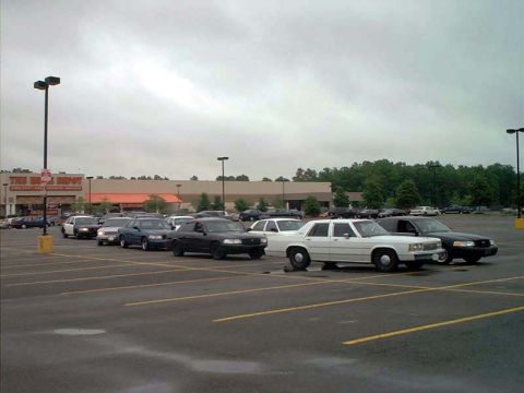 2000 Ford Crown Victoria - Several Ford Crown Victoria sedans are parked in a lot outside a large retail store.