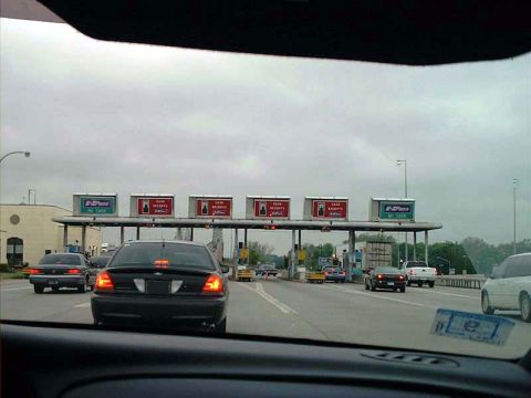 2000 Ford Crown Victoria - A black 2000 Ford Crown Victoria is seen approaching a toll booth on a cloudy day.