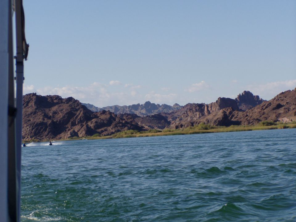 Desert river with personal watercraft and rocky mountains beyond