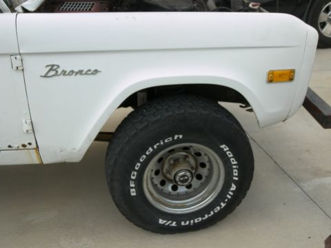1974 Ford Bronco - Close-up view of the fender and wheel of a white Bronco.
