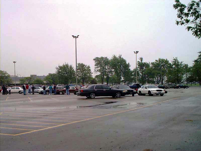 Cars parked in a lot with people milling around