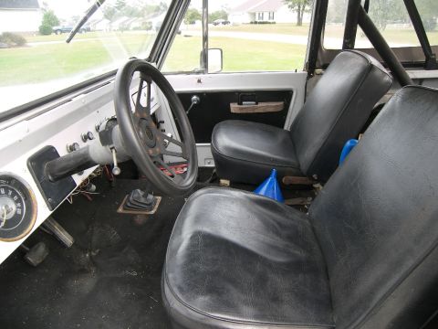 1974 Ford Bronco - The interior of a classic Ford Bronco, black vinyl seats and a manual transmission shifter.