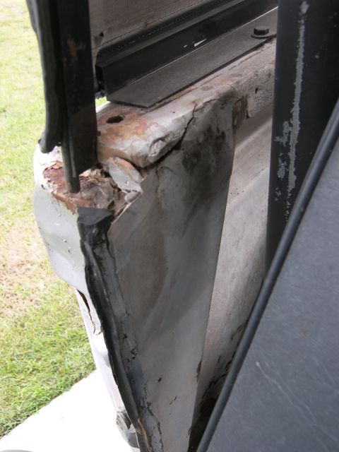 1974 Ford Bronco - Close-up of severely corroded and damaged vehicle frame section.