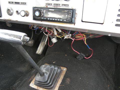 1974 Ford Bronco - Exposed wiring and a stereo are visible under the dashboard of this vehicle's interior.