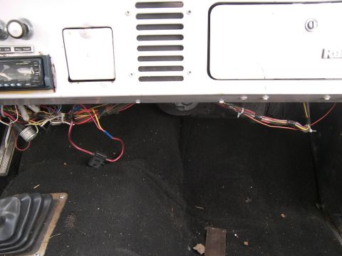 1974 Ford Bronco - A close-up view of the complex wiring beneath the dashboard of a vehicle.