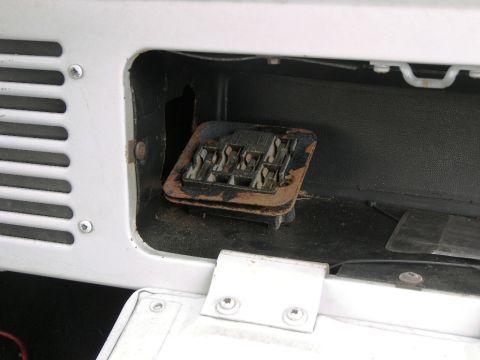 1974 Ford Bronco - Close-up view of a vehicle's fuse box, showing a rusty metal bracket and exposed terminals.
