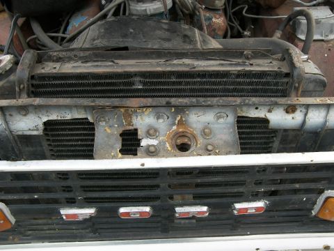1974 Ford Bronco - The front grille and radiator of a vintage Ford Bronco are shown, with visible wear on the radiator.