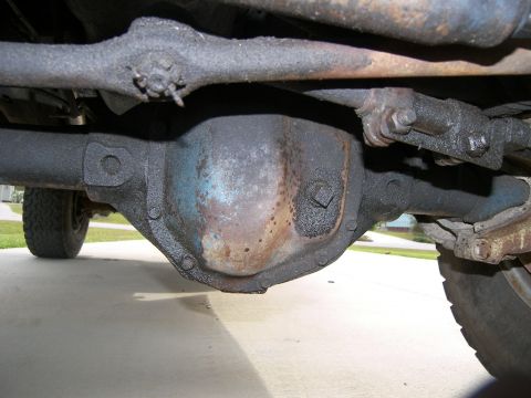 1974 Ford Bronco - The rear axle differential is covered in grease and shows signs of wear and tear.