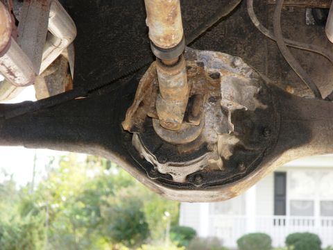 1974 Ford Bronco - The rear axle differential shows signs of rust and wear, with a driveshaft U-joint visible above it.