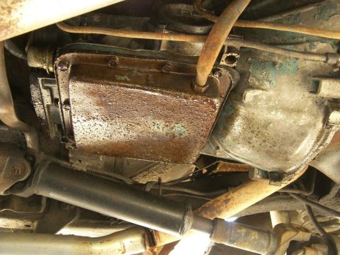1974 Ford Bronco - Underside view of a vehicle's transmission and driveshaft, showing signs of rust and wear.