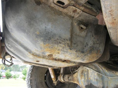 1974 Ford Bronco - The undercarriage shows significant rust on the fuel tank and rear axle components.