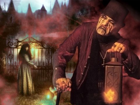 1976 International Scout II - A man in a top hat and dramatic makeup holds a lantern, standing before a gothic gate with a woman and imposing structures behind him.