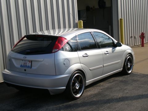 2003 Ford Focus - The rear three-quarter view of a silver Ford Focus hatchback is captured in this image.
