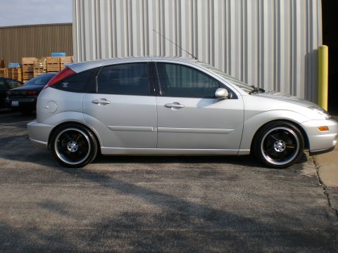 2003 Ford Focus - Side view of a silver 2003 Ford Focus hatchback with aftermarket wheels.