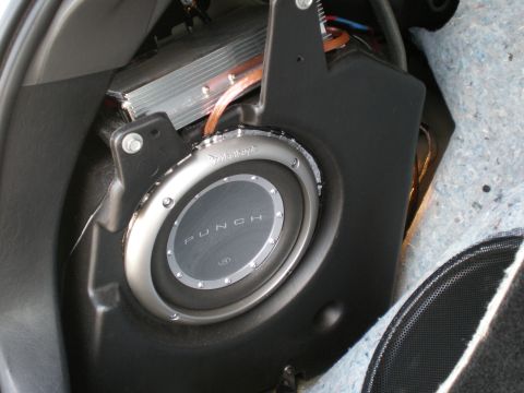 2003 Ford Focus - Aftermarket audio equipment, including a subwoofer and amplifier, is installed in the trunk area of a vehicle.