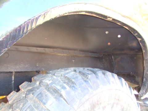 1979 Ford Bronco - Close-up view of a vehicle's wheel well, revealing the tire and undercarriage details.