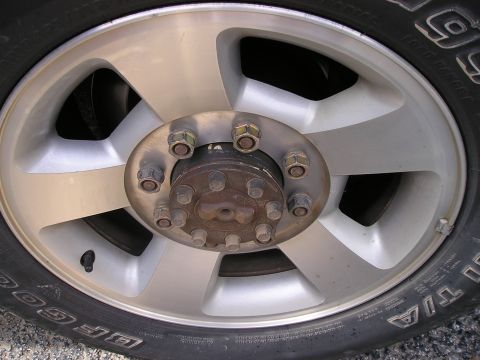 1989 Ford Bronco - This image shows a close-up of a vehicle's wheel and tire, a silver alloy rim with eight lug nuts and a BFGoodrich tire.