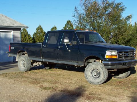 1996 Ford F-350 - This dark blue Ford F-350 pickup truck is shown from the front three-quarter angle, parked outdoors.