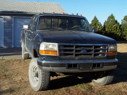 1996 Ford F-350 - Front view of a dark blue 1996 Ford F-350 pickup truck parked in front of a garage.