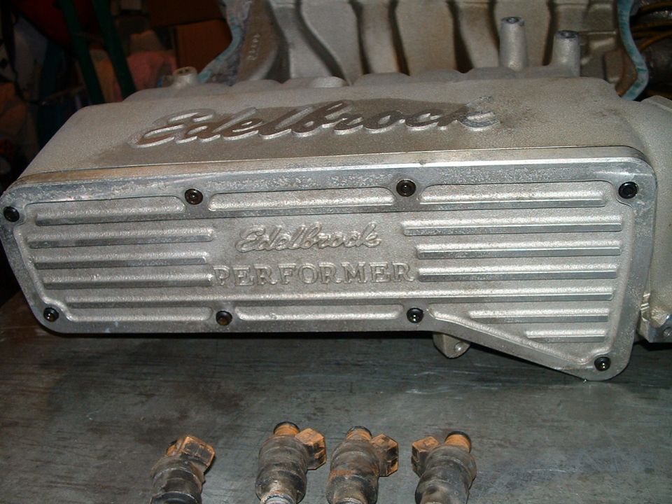 Aluminum Edelbrock Performer intake manifold with four fuel injectors in foreground