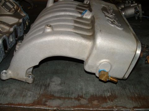 1995 Ford Bronco - A silver supercharger intake manifold is shown, with visible blue fittings and a Supermotors.net watermark.