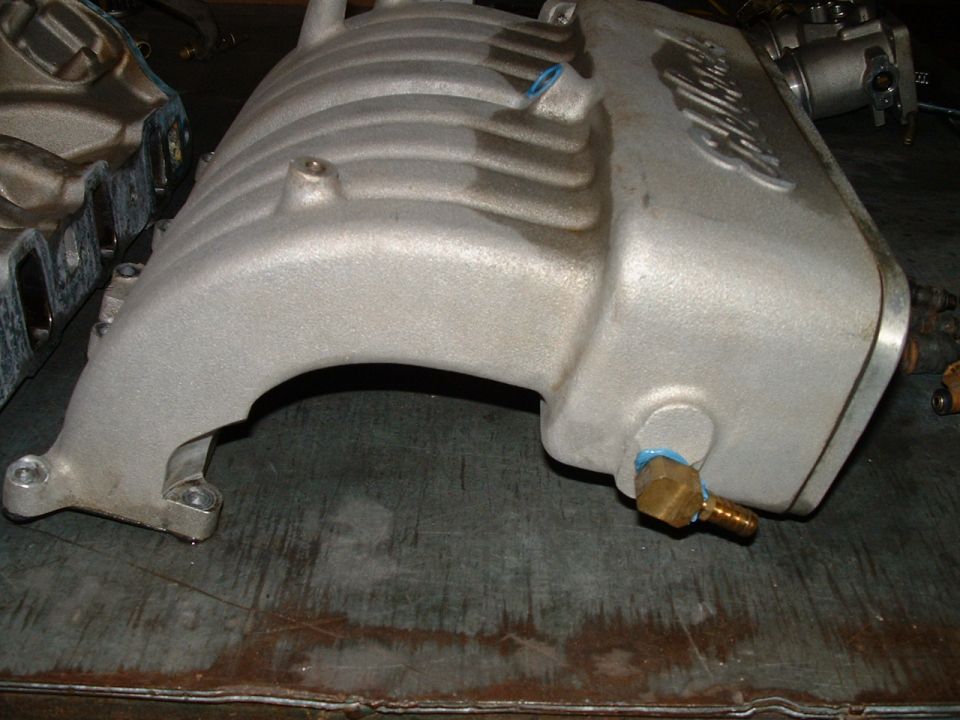 Silver supercharger intake manifold with blue fittings