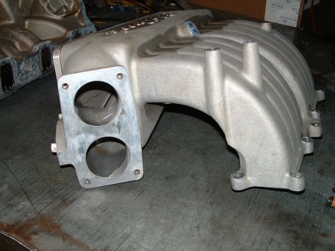 1995 Ford Bronco - This is an aluminum intake manifold, likely for a V8 engine, shown on a workbench.