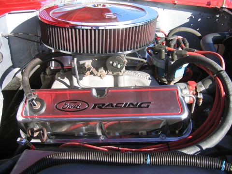1969 Ford Bronco - Chrome valve covers with red trim read 'Ford Racing' above engine components.