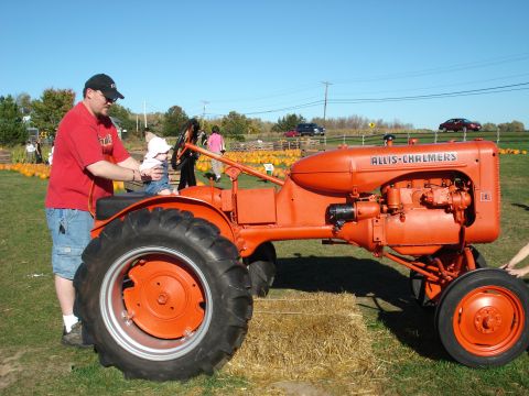 2000 Ford Crown Victoria - A man holds a baby on a vintage Allis-Chalmers tractor at a pumpkin patch.