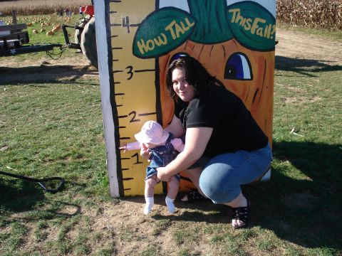 2000 Ford Crown Victoria - A woman and a baby pose for a photo next to a festive pumpkin-themed height chart at a pumpkin patch.