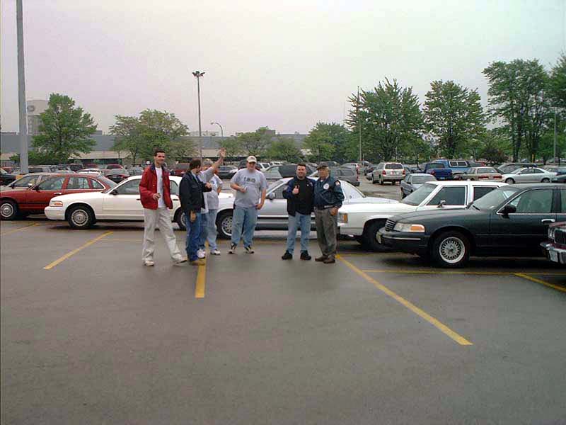 Dark green 2000 Ford Crown Victoria parked in a lot with several people