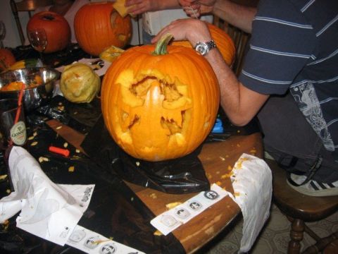 1989 Ford Bronco - People are carving pumpkins for Halloween on a table covered in pumpkin debris.