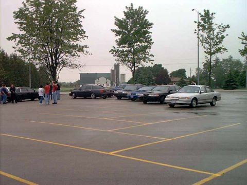 2000 Ford Crown Victoria - A silver sedan is parked in a lot with several other vehicles, suggesting a 1998 model year based on its body style.