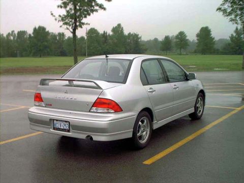 2000 Ford Crown Victoria - A silver Mitsubishi Lancer is parked in a lot on a cloudy day. The license plate is visible.