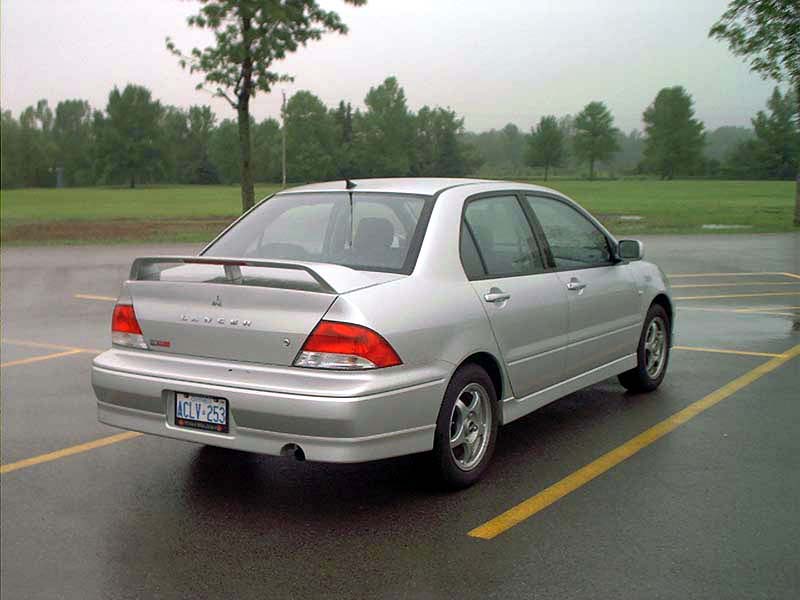 Silver Mitsubishi Lancer parked in a lot, rear view. License plate is ICLV-253