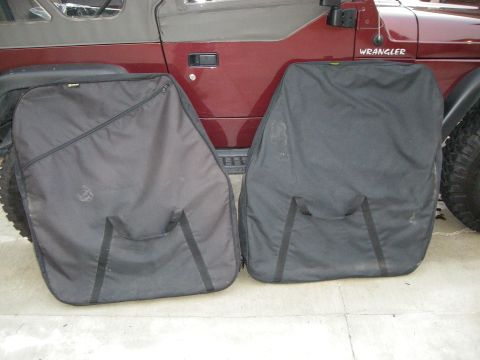 1995 Ford Bronco - Maroon Jeep Wrangler with two black storage bags positioned in front of it.