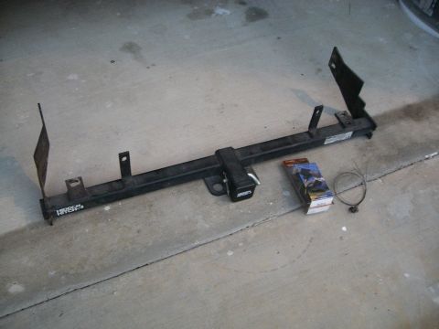 1995 Ford Bronco - A trailer hitch is shown on a concrete surface, accompanied by a small package and a zip tie.