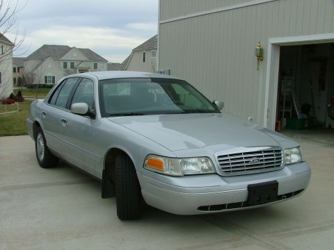 2001 Ford Crown Victoria - This 2001 Ford Crown Victoria is captured in a three-quarter front view, parked on a concrete driveway.