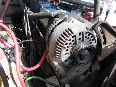 1979 Ford F-150 - Close-up view of an alternator and associated wiring within a vehicle's engine compartment.