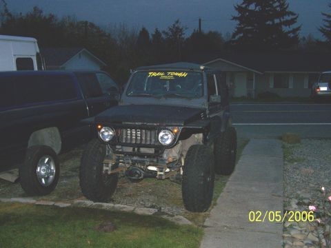 1988 Suzuki Samurai - A modified Suzuki Samurai is parked in a driveway next to a dark pickup truck.