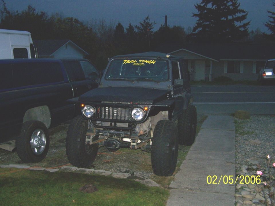 Modified Suzuki Samurai with large tires and "TRAIL TOUGH" sticker on windshield