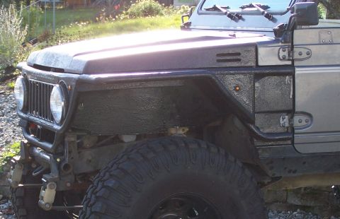 1988 Suzuki Samurai - Front view of a modified 1988 Suzuki Samurai showing its grille, fender, and off-road tire.