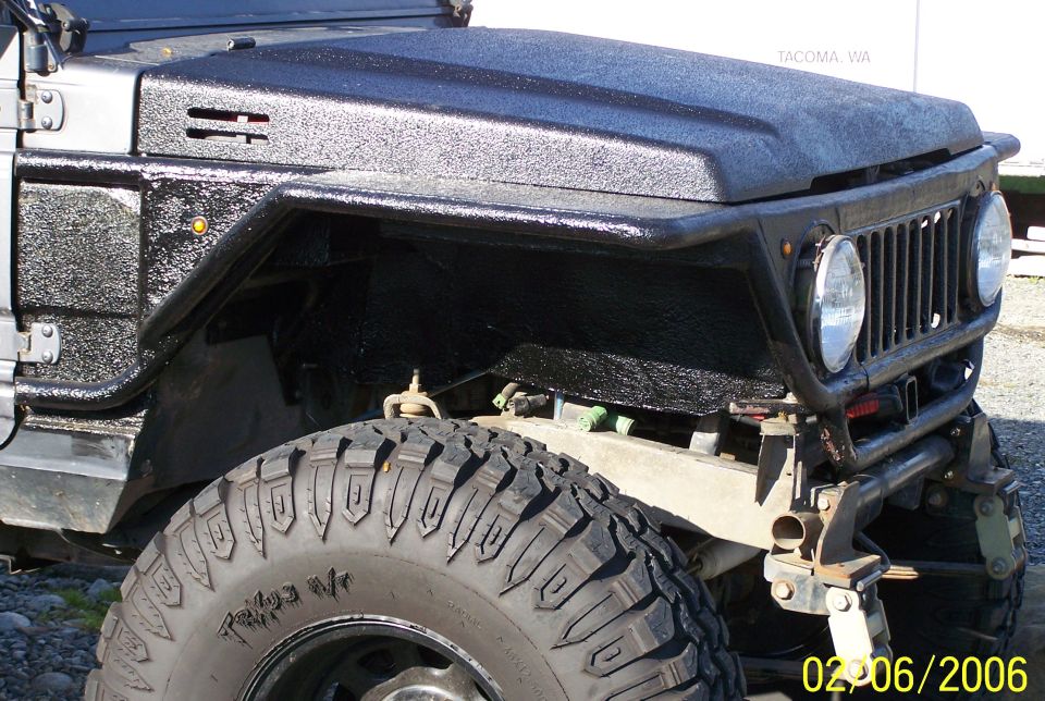 Lifted Suzuki Samurai front corner with bedliner-coated tube fenders and mud-terrain tire