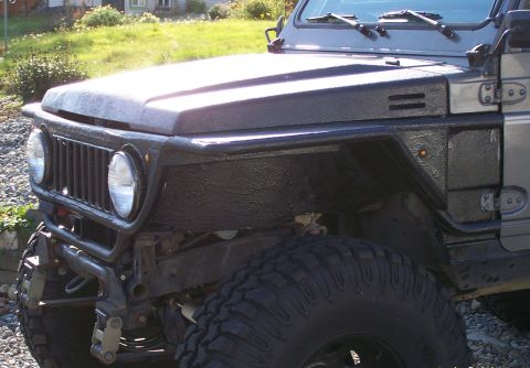 1988 Suzuki Samurai - Close-up of the front fender and grille of a 1988 Suzuki Samurai.