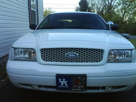 2003 Ford Crown Victoria - Front view of a white 2003 Ford Crown Victoria, a custom grille and a UK House license plate.