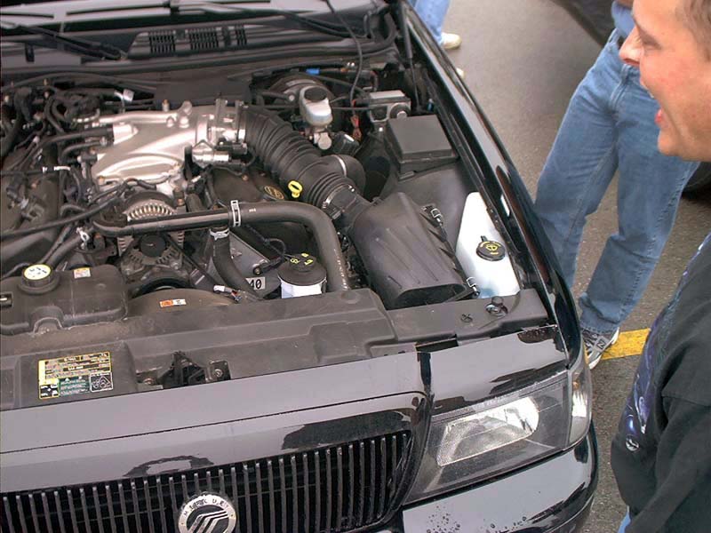 2000 Ford Crown Victoria engine bay with V8 engine, black grille, and headlights visible